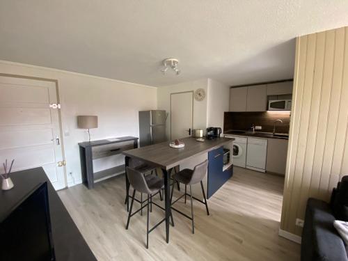 une cuisine avec une table et des chaises dans une pièce dans l'établissement AU BORD DU LAC, à Soustons