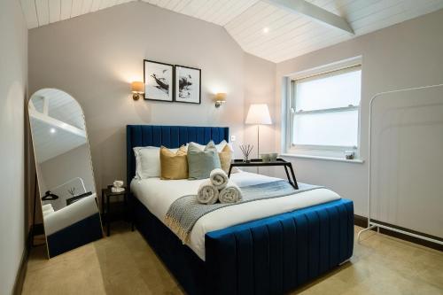 a bedroom with a blue bed in a room at Livestay 2Bed House in Twickenham Private Garden in Twickenham