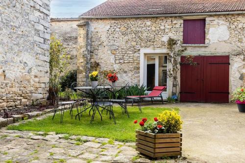 a patio with a table and chairs in front of a building at Gîte Astara Ury in Ury