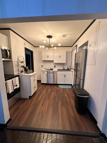 a large kitchen with white cabinets and a hard wood floor at Relaxing Home in Savannah, Ga area in Savannah
