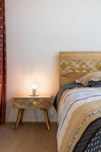 a bedroom with a bed and a nightstand with a lamp at Gîte Astara Ury in Ury