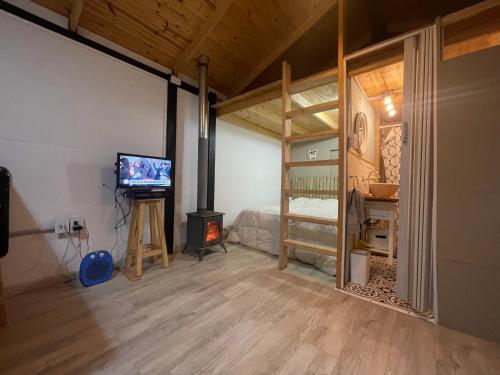 a bedroom with a bunk bed and a television and a fireplace at TINY HOUSE Potrerillos in Potrerillos