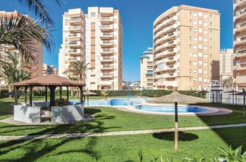 ein Pool mit Sonnenschirmen in einem Park mit hohen Gebäuden in der Unterkunft Apartamentos Puerto Mar V.v. in La Manga del Mar Menor