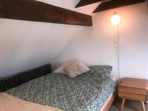 1 dormitorio con 1 cama y 1 lámpara en la pared en En-suite with double bed on mezzanine and desk in family home en Hertford