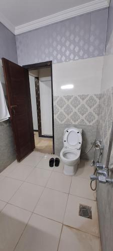 een badkamer met een toilet en een deur open bij Concept Guest House in Islamabad
