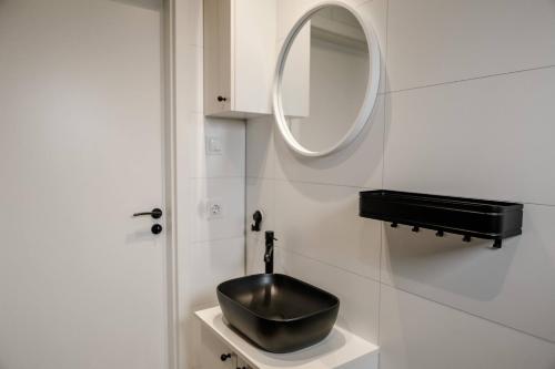 een badkamer met een zwarte wastafel en een spiegel bij Luxe chalet + sauna in Waarde in Waarde