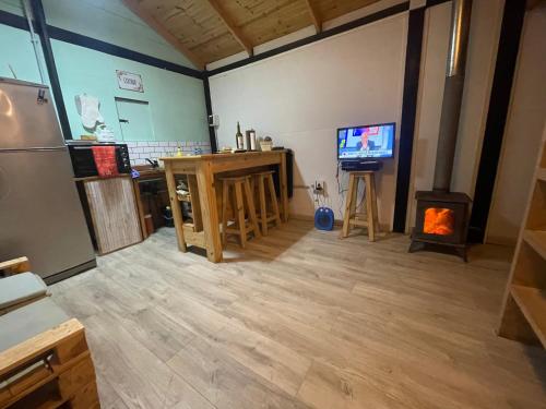 a living room with a television and a stove at TINY HOUSE Potrerillos in Potrerillos
