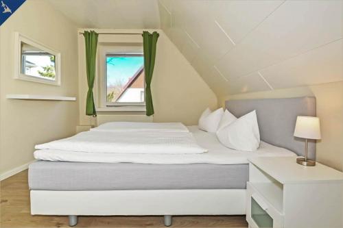 een bed in een kleine kamer met een raam bij Apartment Atelier in Bansin