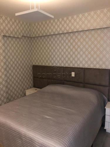 a bed in a bedroom with a wall at Apartamento todo mobiliado - Completo! in Sao Jose do Rio Preto