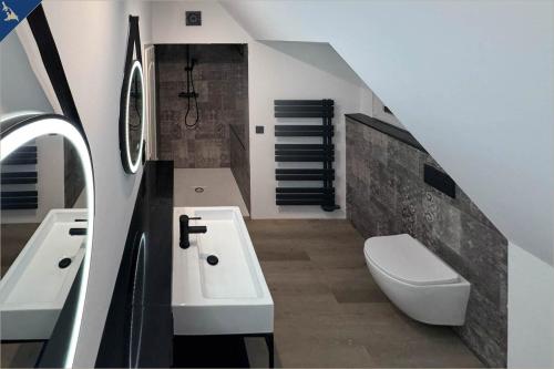 een badkamer met een wastafel, een toilet en een trap bij Apartment Atelier in Bansin