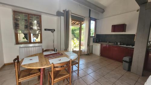une cuisine et une salle à manger avec une table et des chaises dans l'établissement Gîtes Les Fées du Gard - Au pied des Cévennes, à Rousson