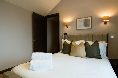 a bedroom with a bed with green and white pillows at 2Bed House Twickenham With Private Garden in Twickenham