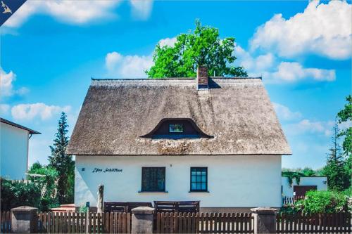 a white house with a roof with a fence at Apartment Nähstube in Bansin