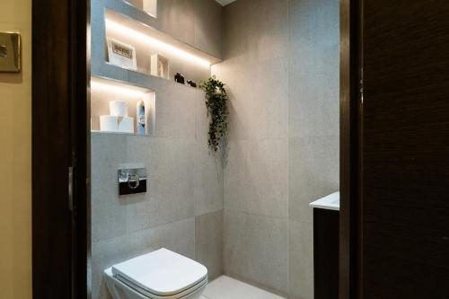 a bathroom with a toilet and lights in it at 2Bed House Twickenham With Private Garden in Twickenham