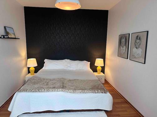 - une chambre avec un grand lit blanc et deux lampes dans l'établissement Hamngatan 35 C, à Simrishamn