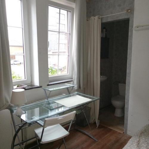 een badkamer met een glazen bureau en een toilet bij Maison Bohème 