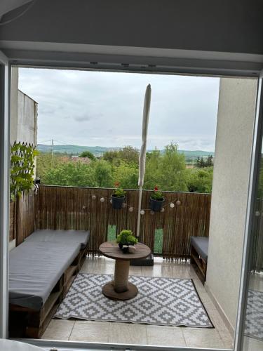 een patio met een tafel en een bank op een balkon bij Sunset apartment in Sângeorgiu de Mureş