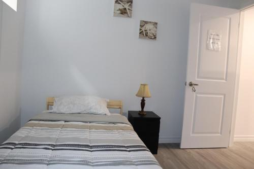 a bedroom with a bed and a white door at Cozy place, 15 min to Niagara Falls & USA border. in Thorold