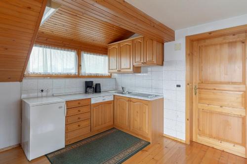 a kitchen with wooden cabinets and a white dishwasher at Apartmaji Marko in Bled