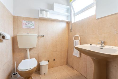 a bathroom with a toilet and a sink at Blife Faro Beach Hostel & Rooms in Faro