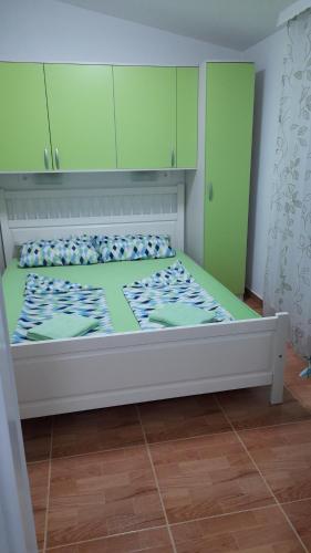 um quarto com uma cama grande e armários verdes em Apartment HORVAT 2 em Vir