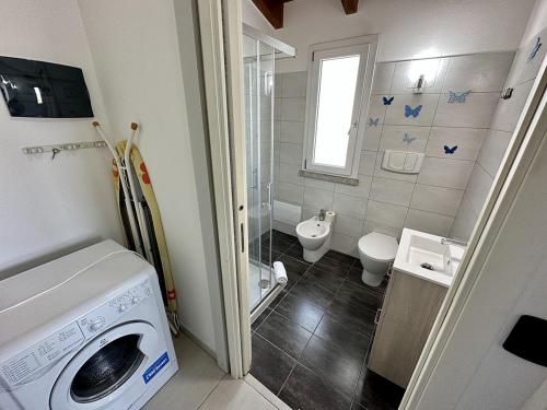 een badkamer met een wasmachine en een toilet bij Grazioso e panoramico appartamento in zona residenziale a Sant'Antioco C54 in SantʼAntìoco