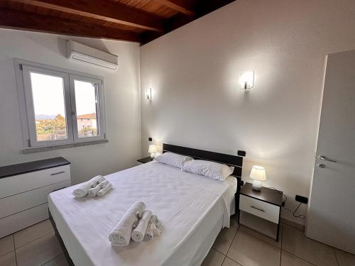 een slaapkamer met een bed met handdoeken erop bij Grazioso e panoramico appartamento in zona residenziale a Sant'Antioco C54 in SantʼAntìoco