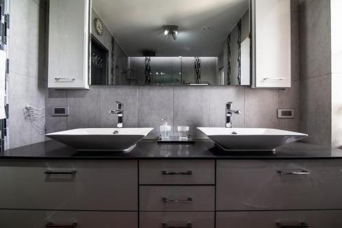 ein Badezimmer mit zwei Waschbecken auf einer schwarzen Theke in der Unterkunft Lovely 3-Bed Apartment in Maho in Maho Reef