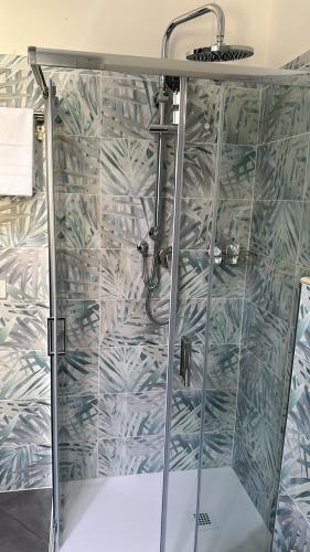 La salle de bains est pourvue d'une douche avec une porte en verre. dans l'établissement Domora mini Apartament nicolò, à Ortona