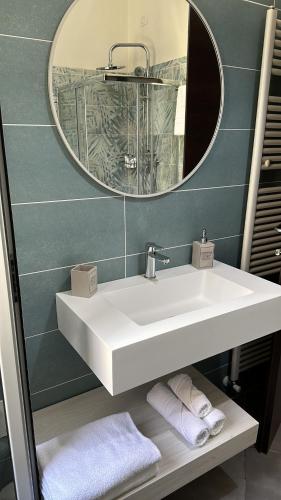 La salle de bains est pourvue d'un lavabo blanc et d'un miroir. dans l'établissement Domora mini Apartament nicolò, à Ortona