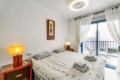 ein Schlafzimmer mit einem großen Bett und einem Balkon in der Unterkunft Luxe appartement 20 - Punta Glea in Playas de Orihuela