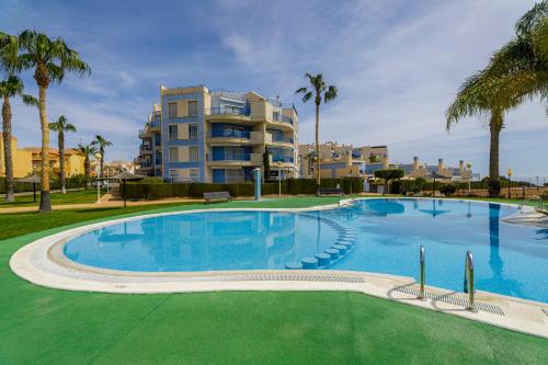 ein großer Pool mit einem Gebäude im Hintergrund in der Unterkunft Luxe appartement 20 - Punta Glea in Playas de Orihuela