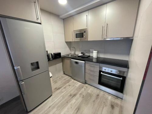 a kitchen with stainless steel appliances and white cabinets at Immodelpas Pessons in Pas de la Casa