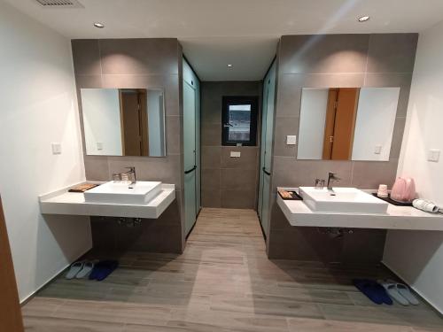 a bathroom with two sinks and two mirrors at Huang Mountain Wangfeng Hotel in Huangshan Scenic Area