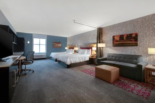 une chambre d'hôtel avec un lit et un canapé dans l'établissement Home2 Suites by Hilton Tuscaloosa Downtown University Boulevard, à Tuscaloosa