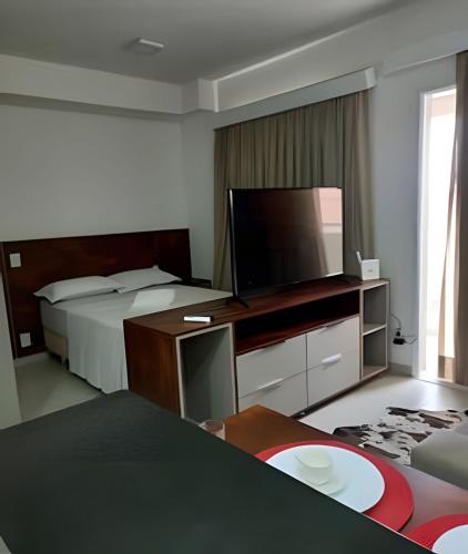 a hotel room with two beds and a flat screen tv at FLATS - DUO JK in Sao Jose do Rio Preto