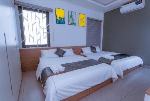 1 dormitorio con 2 camas y 2 ventanas en Hilly Villa Hue, en Cư Chinh