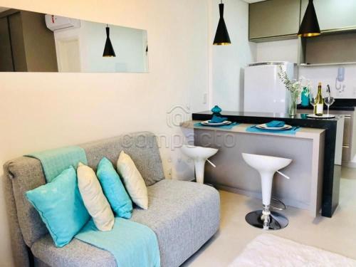 a living room with a couch and a kitchen at FLATS - DUO JK in Sao Jose do Rio Preto