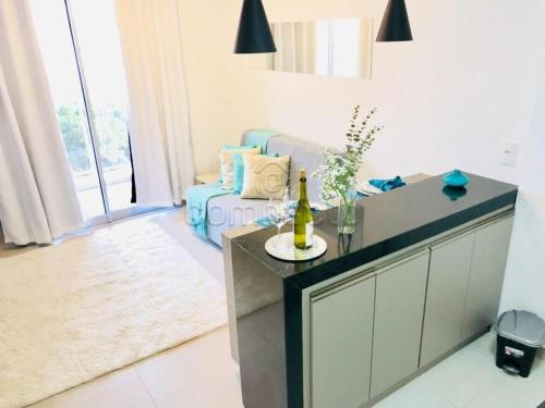 a living room with a couch and a table with a bottle of wine at FLATS - DUO JK in Sao Jose do Rio Preto
