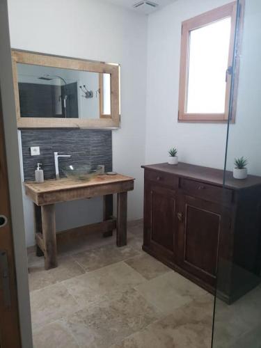une salle de bain avec un lavabo et un miroir dans l'établissement Maison du mur jaune, à Tourtoirac