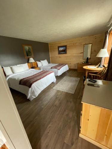 a hotel room with two beds and a table at Spillover Motel and Inn in Stratton