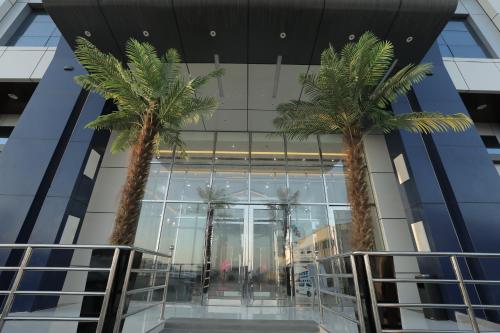 a building with palm trees in front of it at nesto in Manāwirah