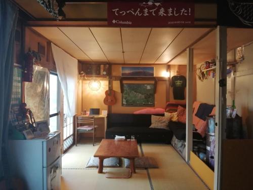 a living room with a couch and a table at Yukiumi House in Kamikawa