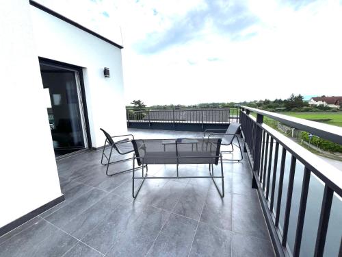 a patio with two chairs and a table on a balcony at Weißes Haus in Gerasdorf bei Wien