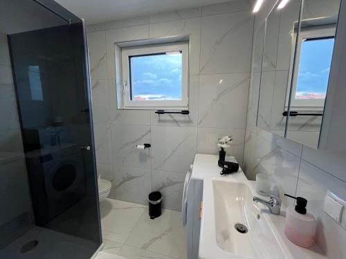 y baño blanco con lavabo y ducha. en Weißes Haus en Gerasdorf bei Wien