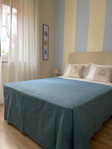un letto con una coperta blu sopra in una camera da letto di Locanda Kon Tiki ad Alassio