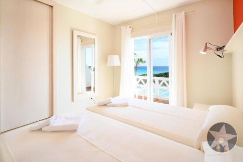a bedroom with two beds and a view of the ocean at Apartamento 4 en primera linea de mar in Santo Tomás