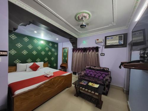 a bedroom with a bed and a chair in it at Abhishek Inn New Digha in Digha