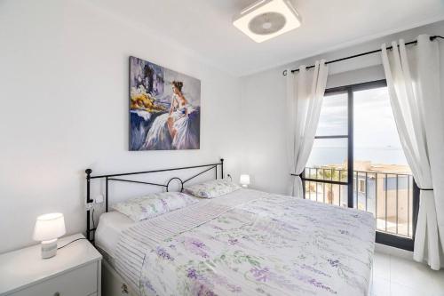 オリフエラ・コスタにあるLovely appartment with stunning sea view, 2nd floorのベッドルーム1室(ベッド1台、大きな窓付)