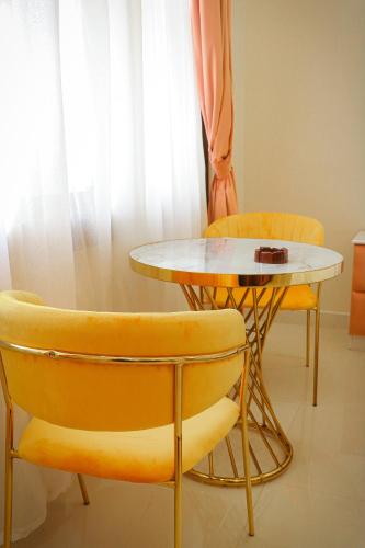 a table and two chairs and a table and a table at Nesto Hotel in Manāwirah